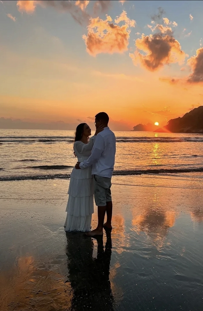 Heloisa e Gustavo abraçados na praia ao pôr do sol